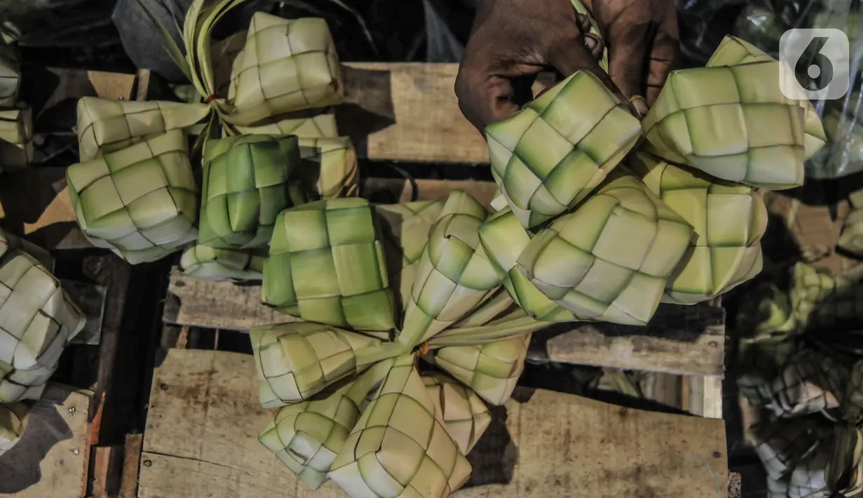 Aktivitas pedagang saat membuat bungkus atau tali ketupat di Pasar Klender, Jakarta Timur, Selasa (11/5/2021) malam. Biasanya empat hari menjelang Lebaran pedagang ketupat musiman tersebut mulai bermunculan menjajakan bahan baku makanan khas Idul Fitri ini. (merdeka.com/Iqbal S Nugroho)