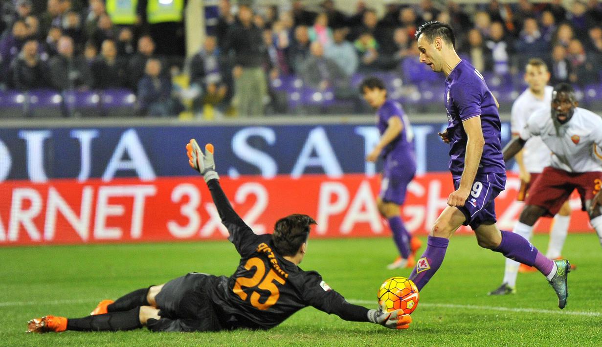 Pemain Fiorentina, Nikola Kalinic (kanan) berusaha menaklukkan kiper  Roma, Wojciech Szczesny, dalam lanjutan Serie A Italia di Stadion Artemio Franchi, Florence, Senin (26/10/2015) dini hari WIB. (EPA/Maurizio Degl'Innocenti)
