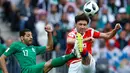 Pemain Rusia Yuri Zhirkov berebut bola dengan pemain Arab Saudi Taiseer Aljassam saat pertandingan grup A Piala Dunia 2018 di stadion Luzhniki di Moskow, Rusia, (14/6). Rusia menang telak 5-0. (AP Photo/Hassan Ammar)