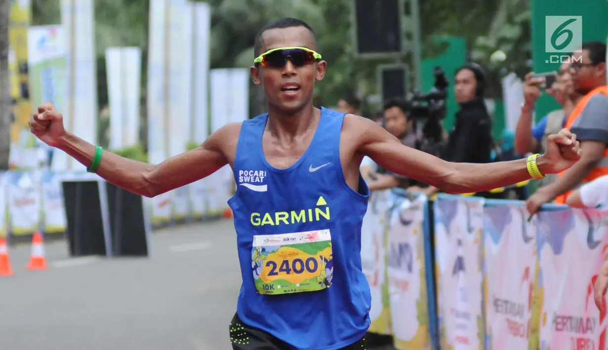 Pelari nasional, Agus Prayogo membentangkan tangan usai finish pertama di ajang Pertamina Eco Run 2017 kategori 10K umum pria di Pantai Karnaval Ancol, Jakarta, Sabtu (16/12). Agus mendapat hadiah tunai 15 juta rupiah. (Liputan6.com/Helmi Fithriansyah)