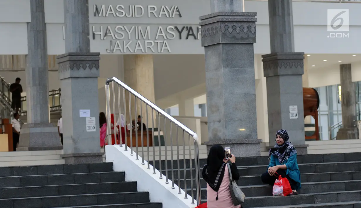 Warga berfoto di sekitar halaman Masjid Raya KH Hasyim Asyari Jakarta, Senin (29/5). Di hari ketiga Ramadan belum nampak kegiatan menonjol yang diadakan saat menanti datangnya waktu berbuka puasa. (Liputan6.com/Helmi Fithriansyah)