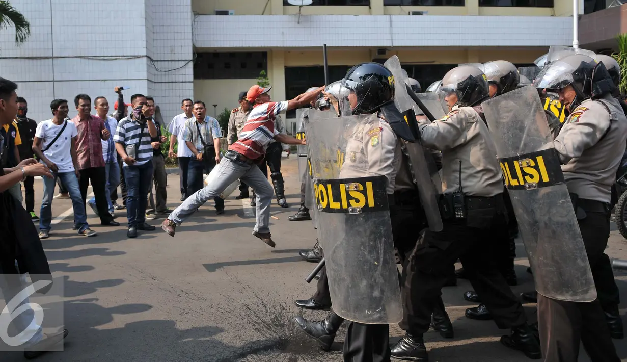 Seorang pria terlihat menyerang petugas saat simulasi pengamanan pilkada Tangerang Selatan yang digelar Polres Jakarta Selatan, Rabu (9/9/2015). (Liputan6.com/Gempur M Surya)