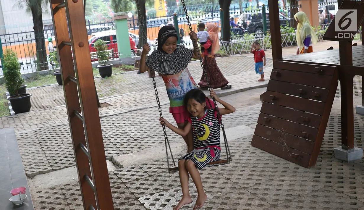 Dua bocah bermain ayunan di sekitar RPTRA Kebon Sirih, Jakarta, Jumat (4/8). Untuk mewujudkan kota ramah anak, Pemprov DKI Jakarta menargetkan adanya ruang publik terpadu ramah anak (RPTRA) di setiap RW se-DKI Jakarta. (Liputan6.com/Immanuel Antonius)