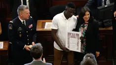 Imigran Mali Mamoudou Gassama dianugerahi medali Grand Vermeil oleh walikota Paris Anne Hidalgo (kanan) di Paris, Prancis (4/6). Sebelumnya Mamoudou dijuluki "Spider-Man" karena menyelamatkan balita yang nyaris jatuh dari apartemen. (AFP/Francois Guillot)