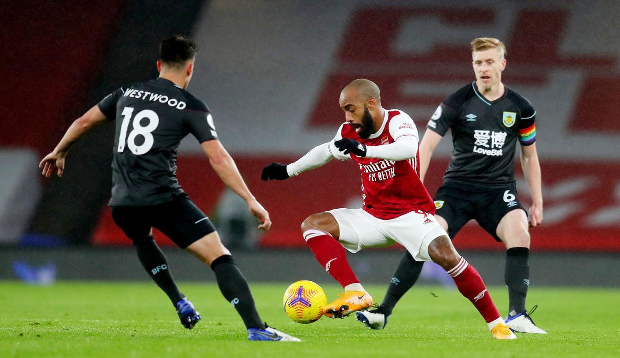 Striker Arsenal, Alexandre Lacazette, berusaha melewati pemain Burnley pada laga Liga Inggris pada laga Liga Inggris di Stadion Emirates, Senin (14/12/2020). Arsenal takluk 0-1 dari Burnley. (Laurence Griffiths/Pool/AFP)