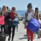 Turis asing yang dievakuasi dari Gili Trawangan tiba di Pelabuhan Bangsal, Lombok Utara, NTB, Selasa (7/8). Gempa 7 skala Richter mengguncang Lombok dan menewaskan 91 orang. (ADEK BERRY/AFP)