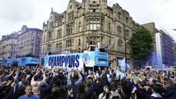 Para pemain Manchester City menyapa para penggemar dari atas bus saat parade kemenangan Liga Inggris di Manchester, Inggris, 23 Mei 2022. (AP Photo/Jon Super)