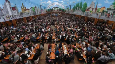 Pengunjung menikmati bir selama Festival Oktoberfest 2019 di sebuah tenda di Munich, Jerman selatan (3/10/2019). Festival bir terbesar di dunia Oktoberfest berlangsung hingga 6 Oktober 2019. (AFP Photo/Christof Stache)