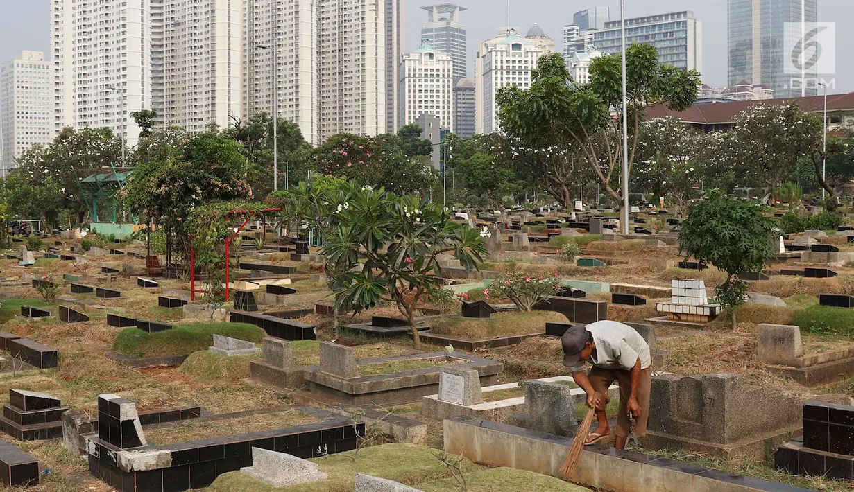 Pekerja membersihkan makam di TPU Karet Bivak, Jakarta, Kamis (26/7). Wagub DKI Jakarta Sandiaga Uno menyatakan akan mencari dan memerbanyak area TPU di Ibukota yang akan dimasukkan dalam anggaran Pemprov DKI tahun depan. (Liputan6.com/Immanuel Antonius)
