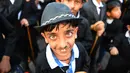 Ekspresi seorang anak berpenampilan seperti Charlie Chaplin berpose memperingati ulang tahun Charlie Chaplin ke-129 di Adipur, sekitar 60 km barat laut Bhuj di negara bagian Gujarat, India barat (16/4). (AFP Photo/Indranil Mukherjee)