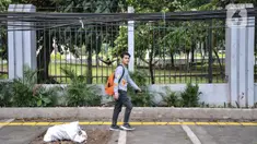 Pejalan kaki melintas di dekat kabel utilitas yang menjuntai di Jalan Proklamasi, Pegangsaan, Kecamatan Menteng, Jakarta Pusat, Kamis (6/10/2022). Minimnya pengawasan dalam tahap penyelesaian proyek revitalisasi trotoar oleh pihak terkait menyebabkan jaringan kabel utilitas di kawasan tersebut semrawut  yang dapat membahayakan keselamatan pengguna jalan, terutama saat musim penghujan. (merdeka.com/Iqbal S. Nugroho)