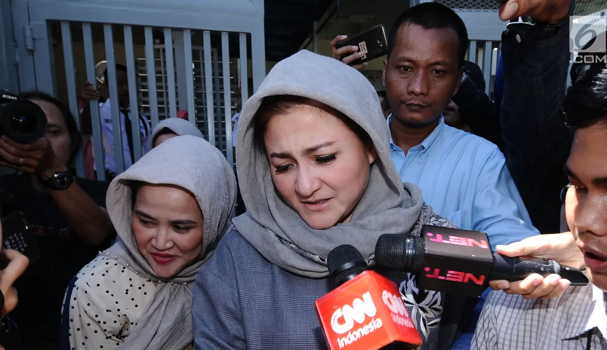 Istri Setya Novanto, Deisti Astriani Tagor menghindari kejaran pewarta usai mengunjungi SN di Rutan KPK, Jakarta, Senin (25/12). Sejumlah anggota keluarga Setya Novanto hadir menjenguk pada libur Hari Natal kali ini.  (Liputan6.com/Helmi Fithriansyah)
