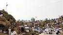 <p>Jemaah haji berkumpul di sekitar Jabal al-Rahma (Gunung Rahmat) saat menunaikan prosesi wukuf di Padang Arafah, tenggara Kota Suci Mekah, Arab Saudi, Senin (19/7/2021). Wukuf di Padang Arafah dua tahun terakhir berada dalam pembatasan karena pandemi corona virus COVID-19. (FAYEZ NURELDINE/AFP)</p>
