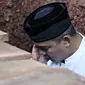 Presenter Farhan saat mengazdani anak pertamanya Muhammad Ridzky Khalid di TPU Tanah Kusir, Jakarta, Senin (21/12). Ridzky menghebuskan nafas terakhirnya di usia 16 tahun pada Minggu, (20/12/2015) pukul 13.40 WIB. (Liputan6.com/Immanuel Antonius)