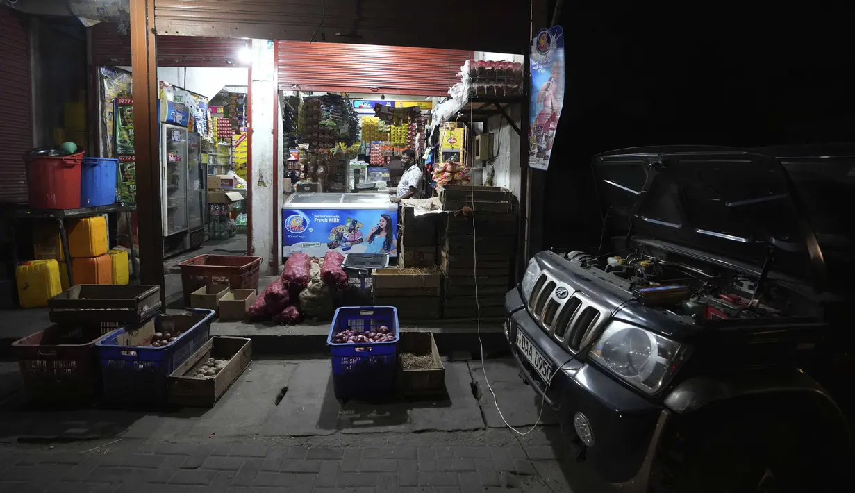 Pengecer menggunakan truk bertenaga dieselnya untuk menerangi outlet penjualannya di Kelaniya, Sri Lanka, 3 Maret 2022. Krisis keuangan negara memaksa anak-anak belajar menggunakan lampu minyak tanah, nelayan mengurangi penangkapan ikan dan industri membatasi produksi. (AP Photo/Eranga Jayawardena)