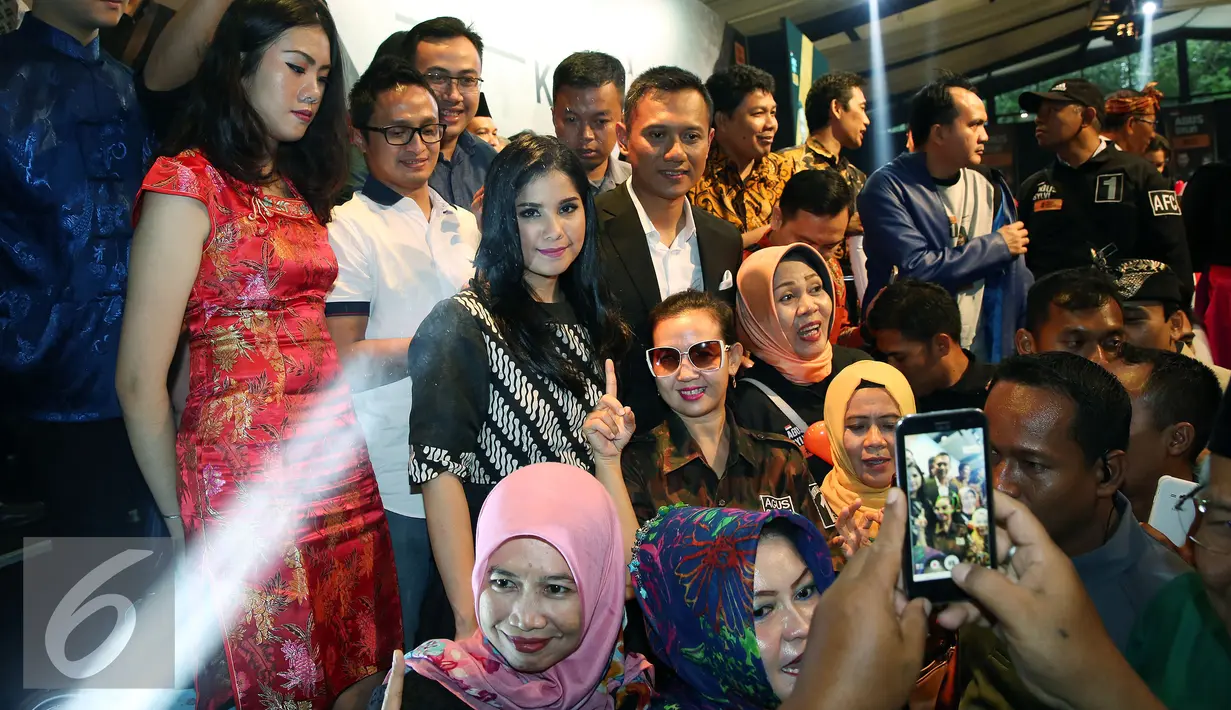Cagub DKI Jakarta Agus Harimurti Yudhoyono didampingi istri berfoto dengan simpatisan usai pidato politik membahas NKRI dan Kebhinnekaan, Jakarta, Sabtu (11/12). (Liputan6.com/Johan Tallo)