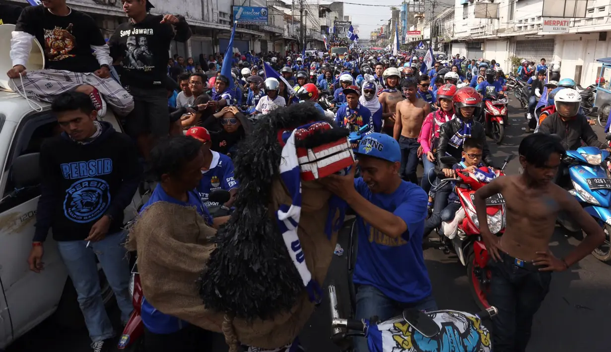Anggota kelompok yang berjumlah 25 orang secara bergantian memanggungkan reog yang terbuat dari karung goni ini dalam Pawai Persib Juara Piala Presiden, Minggu (25/10/2015). (Bola.com/Nicklas Hanoatubun)