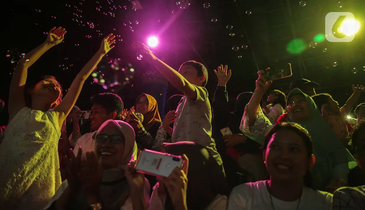 Pengunjung menyaksikan Sinterklas bersama para kurcaci menyuguhkan atraksi di Sharkquarium arena Sea World Ancol, Jakarta, Rabu  (25/12/2019). Sea World Ancol menampilkan atraksi penyelam Scuba Santa pada perayaan Natal 2019. (Liputan6.com/Faizal Fanani)