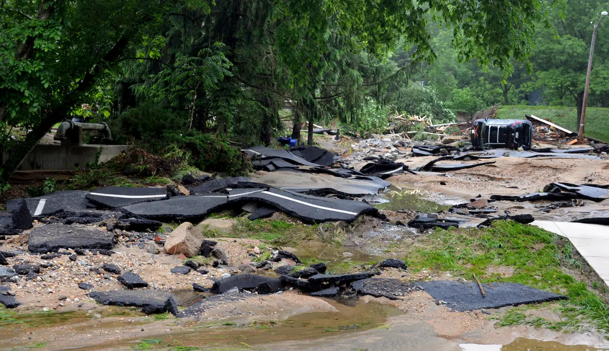 Aspal jalan raya mengelupas tersapu banjir bandang yang melanda Ellicott City, Maryland, Amerika Serikat, Senin (28/5). Banjir serupa yang mematikan, juga pernah terjadi di Maryland pada 2016 lalu. (AP Photo/David McFadden)
