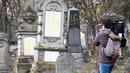 Seorang jurnalis mengambil gambar makam Yahudi yang dicoret simbol Nazi di pemakaman Yahudi, Quatzenheim, Prancis, Selasa (19/2). Prancis merupakan negara Eropa dengan komunitas Yahudi terbanyak yaitu sekitar 550 ribu orang. (Frederick FLORIN/AFP)