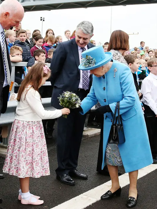 Seorang anak perempuan memberikan bunga kepada Ratu Elizabeth II saat peresmian Queensferry di Skotlandia, Minggu (4/9). Queensferry adalah jenis jembatan kabel pancang yang di desain megah dan  modern. (Andrew Milligan/PA via AP)