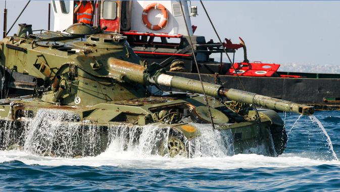 Aktivis lingkungan menenggelamkan sebuah tank lama ke dasar Laut Mediterania di lepas pantai kota pelabuhan Sidon, Lebanon, Sabtu (28/7). Penenggelaman ini diharapkan bisa menciptakan surga baru bagi satwa liar di Laut Mediterania. (AFP / Mahmoud ZAYYAT)