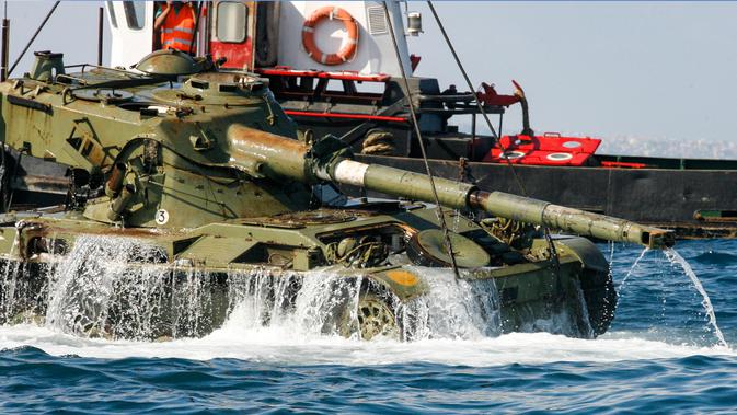 Aktivis lingkungan menenggelamkan sebuah tank lama ke dasar Laut Mediterania di lepas pantai kota pelabuhan Sidon, Lebanon, Sabtu (28/7). Penenggelaman ini diharapkan bisa menciptakan surga baru bagi satwa liar di Laut Mediterania. (AFP / Mahmoud ZAYYAT)