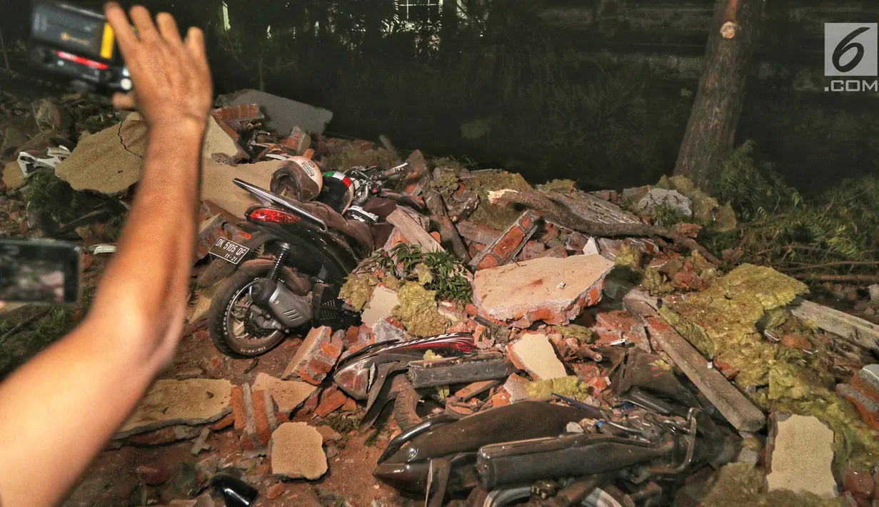 Kendaraan bermotor tertimbun reruntuhan bangunan parkir bertingkat akibat gempa di Mal Galeria, Ngurah Rai, Bali, Minggu malam (5/8). Gempa 7 SR sekitar 27 km Timur Laut Lombok Utara, NTB mengakibatkan bangunan parkir rusak. (Liputan6.com/Johan Tallo)