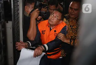 Bupati Pati, Sudewo dikawal petugas sesaat memasuki ke dalam mobil tahanan usai menjalani pemeriksaan intensif di Gedung Merah Putih Komisi Pemberantasan Korupsi (KPK), Jakarta, Selasa (20/1/2026). (Liputan6.com/Helmi Fithriansyah)