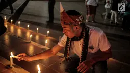 Peserta aksi damai tergabung dalam Pencinta NKRI dan Pancasila menyalakan lilin dengan menggelar doa bersama untuk Papua di Tugu Proklamasi, Menteng, Jakarta, Selasa (20/8/2019). Aksi dengan menyalakan lilin sebagai bentuk solidaritas untuk perdamaian di Tanah Papua. (Liputan6.com/Faizal Fanani)
