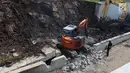 Alat berat menghancurkan beton untuk mengevakuasi mobil yang tertimbun longsor di Underpass Perimeter, Bandara Soetta, Tangerang, Banten, Selasa (6/2). Enam alat berat dikerahkam untuk proses tersebut. (Liputan6.com/Angga Yuniar)