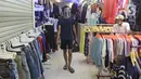 Seorang pria berjalan melewati kios pakaian bekas di Pasar Senen Blok III, Jakarta, Kamis (11/6/2020). Pasar yang tetap buka saat PSBB dengan pembatasan jam operasional ini akan kembali dibuka secara normal pada 15 Juni 2020 dengan aturan protokol kesehatan COVID-19. (Liputan6.com/Herman Zakharia)