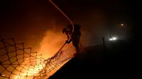 Petugas berusaha memadamkan api dalam kebakaran hutan di kawasan Galicia di Spanyol utara dan Portugal selatan (AFP)
