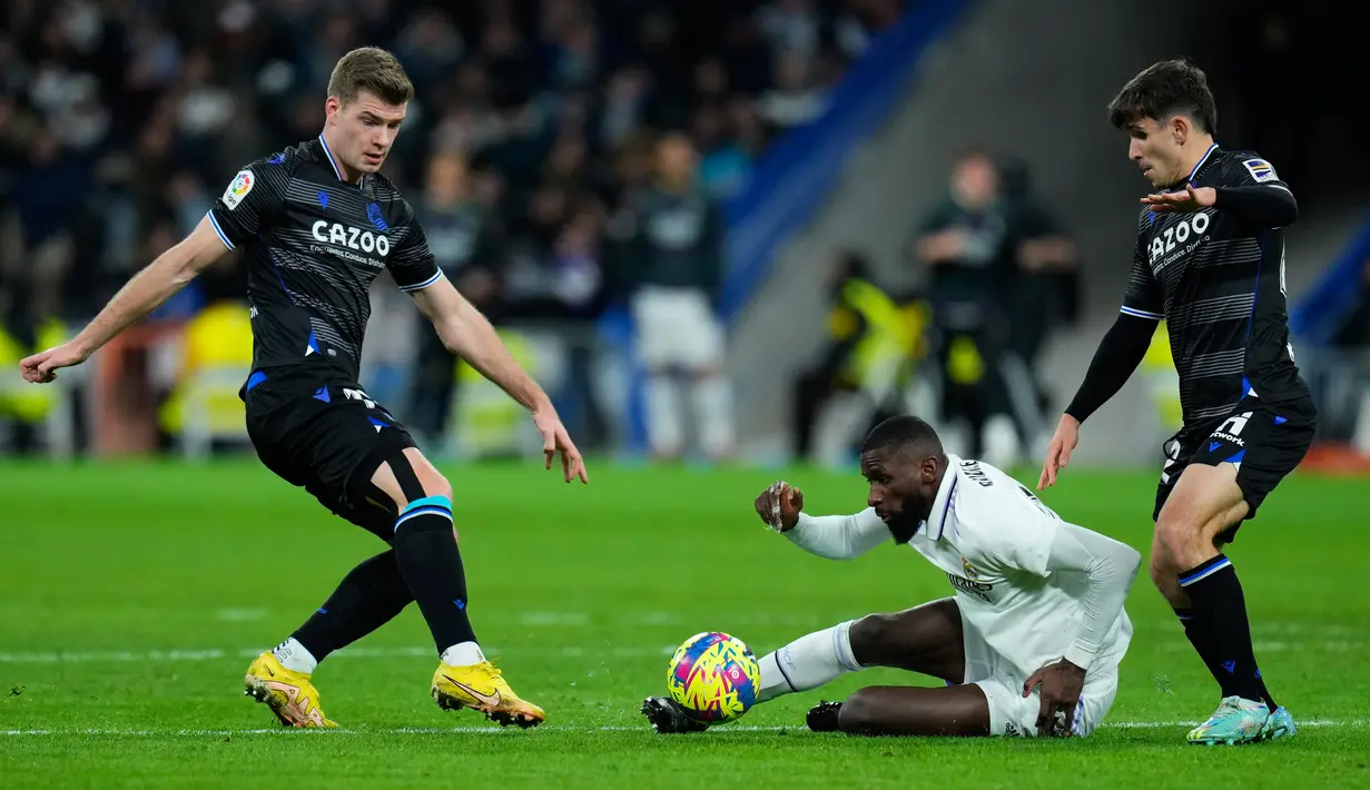 Pemain Real Sociedad Alexander Sorloth (kiri) berebut bola dengan pemain Real Madrid Antonio Rudiger (tengah) pada pertandingan sepak bola Liga Spanyol di Stadion Santiago Bernabeu, Madrid, 29 Januari 2023. Pertandingan berakhir imbang 0-0. (AP Photo/Manu Fernandez)