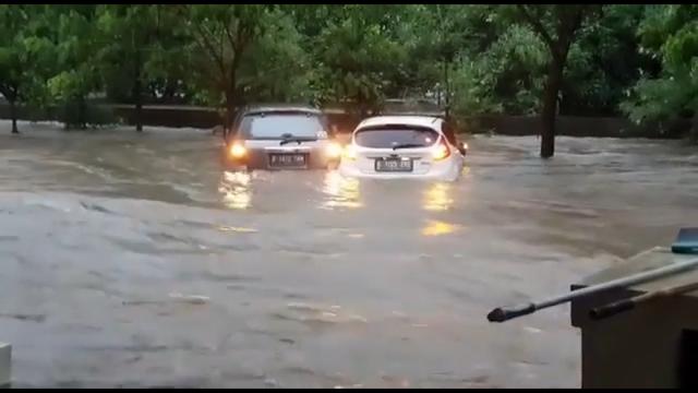 Dua mobil bertahan di tengah banjir