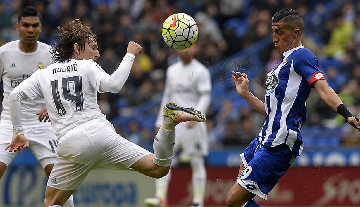 Gelandang Real Madrid, Luka Modric, berebut bola dengan gelandang Deportivo, Faycal Fajr, pada laga La Liga Spanyol. Meskipun menang Madrid gagal menjadi juara Liga Spanyol. (AFP/Miguel Riopa)