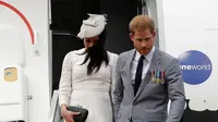 Pangeran Harry dan Meghan Markle turun dari pesawat saat tiba di Suva, Fiji, Selasa (23/10. Banyak fans yang merasa penasaran dengan jenis kelamin calon bayi sang Duchess of Sussex. (AP Photo/Kirsty Wigglesworth, Pool)