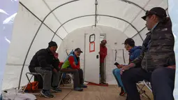 Pendaki menunggu antrean untuk menemui dokter di klinik tenda Everest ER di Everest Base Camp, sekitar 140 Km timur laut Kathmandu, Nepal, 24 April 2018. Saat ini, Everest ER dijalankan oleh Asosiasi Penyelamatan Himalaya. (PRAKASH MATHEMA/AFP)