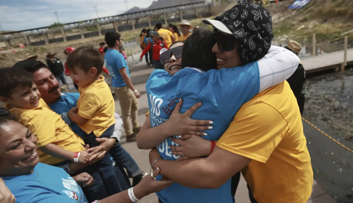 <p>Keluarga di sisi perbatasan Amerika diberi kaos kuning, sementara mereka yang berada di sisi Meksiko mengenakan pakaian biru. (AP Photo/Christian Chavez)</p>