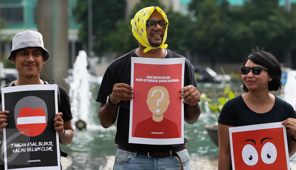 Peserta aksi memegang poster saat aksi peringati hari Hak Asasi Manusia (HAM) 2015 di Bundaran HI, Jakarta, Kamis (10/12/2015). Aksi untuk memperingati Hari HAM Internasional yang jatuh setiap tanggal 10 Desember. (Liputan6.com/Faizal Fanani)