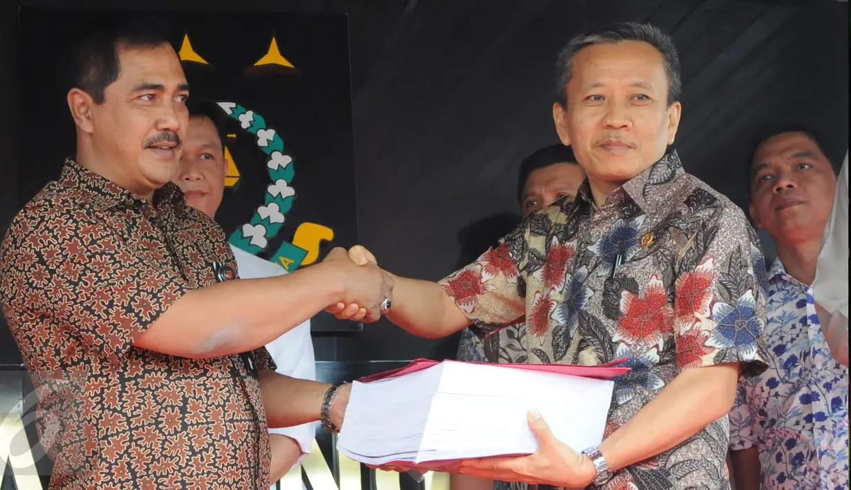 Dirtipidum Bareskrim Polri Brigjen Agus Andrianto (kiri) menyerahkan berkas perkara tahap 1 kepada Ketua Jaksa Peneliti Berkas Perkara Ahok, Ali Mukartono di Kejaksaan Agung, Jakarta, Jumat (25/11). (Liputan6.com/Helmi Afandi)