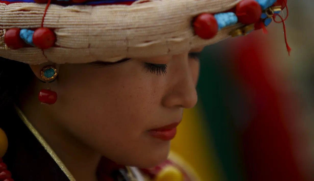 Seorang wanita Tibet mengunakan pakaian tradisional berdoa saat perayaan ulang tahun ke-80 Dalai lama di Kathmandu, Nepal (6/7/2015). Pemeluk Buddha Tibet percaya, Dalai Lama adalah perwujudan insani dari Avalokitesvara. (REUTERS/Navesh Chitrakar)