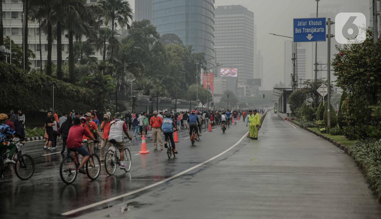 Suasana saat car free day (CFD) di kawasan Bundaran HI, Jakarta, Minggu (29/12/2019). Kendati tidak seramai saat cerah, warga yang berlari, jalan santai, atau swafoto masih menjadi pemandangan di area CFD usai hujan mengguyur Jakarta. (Liputan6.com/Faizal Fanani)