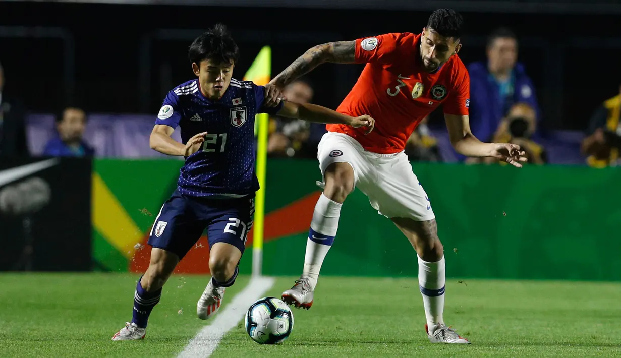Gelandang Jepang, Takefusa Kubo menggiring bola melewati pemain Chile Guillermo Maripan selama pertandingan grup C Copa America 2019 di Stadion Morumbi, Sao Paulo, Brasil (17/6/2019). Kubo merupakan remaja 18 tahun yang dijuluki 'Messi Jepang'. (AP Photo/Victor R. Caivano)