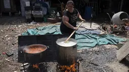 Rosana Sanchez menyiapkan makanan untuk tetangga dan orang-orang yang bekerja di daur ulang, di tempat makan malam populer yang disebut "Cartoneritos," di pinggiran Buenos Aires, Argentina (14/12/2021). Angka kemiskinan mencapai 40,6 persen pada paruh pertama tahun 2021. (AP Photo/Rodrigo Abd)