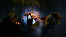 Pemuda Bali saling memukulkan sabut kelapa saat tradisi siat geni atau perang api di Pura Dalam, Tuban, Senin (28/9/2015) malam. Ritual ini diselenggarakan setiap tahun untuk  memohon keselamatan dan menolak bala. (AFP/Sonny Tumbelaka)