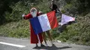 Penonton menggunakan seragam Santa Claus dan membawa bendera Prancis saat memberikan dukungan kepada pebalap Tour de France pada etape ke-19 dengan  jarak tempuh 222,5 km dari Embrun menuju Salon-de-Provence, Prancis, (21/7/2017). (AFP/Lionel Bonaventure)