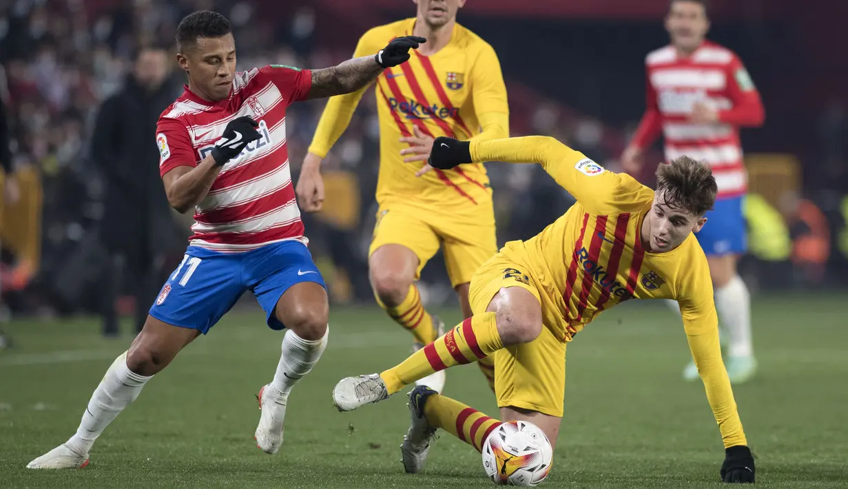 Pemain depan Granada Darwin Machis (kiri) menantang gelandang Barcelona Nico Gonzalez dalam jornada ke-20 Liga Spanyol 2021/2022 di Stadion Los Carmenes, Minggu (9/1/2022) dini hari WIB. Barcelona ditahan imbang 1-1 Granada. (JORGE GUERRERO / AFP)