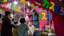 Orang-orang membeli castella pada kios makanan selama pekan raya akhir tahun di Distrik Nihonbashi, Tokyo, Jepang, 26 Desember 2022. Tak hanya menyuguhkan pemandangan indah dan makanan yang lezat, Jepang juga menjadi negara yang tepat untuk merayakan tahun baru. (Yuichi YAMAZAKI/AFP)