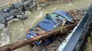 Sebuah mobil tersangkut di tepi sungai usai tersapu banjir bandang yang melanda Ellicott City, Maryland, Amerika Serikat, Senin (28/5). Belum ada laporan resmi tentang korban jiwa dan yang dirawat di rumah sakit. (AP Photo/David McFadden)